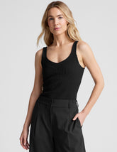 black ribbed tank top with a soft V neckline front and back, overlapping front neckline detail, and a performance lining shelf bra. Tank hits at a high hip length.